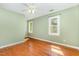 Bedroom with hardwood floors, green walls, a ceiling fan, and two windows at 3109 E Folkestone Pl, Raleigh, NC 27604