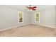 Empty bedroom featuring neutral walls, carpet, a ceiling fan, and two windows at 3109 E Folkestone Pl, Raleigh, NC 27604