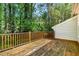 Spacious wooden deck with railing, offering a private outdoor space surrounded by lush trees at 3109 E Folkestone Pl, Raleigh, NC 27604