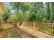 Outdoor deck with a wood railing and trees in the background at 3109 E Folkestone Pl, Raleigh, NC 27604