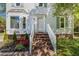 Welcoming home entrance with brick steps, white railings, and manicured landscaping at 3109 E Folkestone Pl, Raleigh, NC 27604