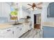 Bright kitchen featuring white cabinets, gray floors, modern appliances and a large sink under a large window at 3109 E Folkestone Pl, Raleigh, NC 27604