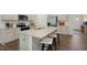 Modern kitchen featuring stainless steel appliances, light cabinetry, granite countertops, and a kitchen island with seating at 320 Hanging Elm Ln, Fuquay Varina, NC 27526