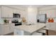 Open-concept kitchen with granite countertops, stainless steel appliances, and a center island with barstool seating at 320 Hanging Elm Ln, Fuquay Varina, NC 27526