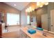 Bathroom featuring double sinks, a bathtub, a shower with glass doors, and neutral tile at 3219 Ranbir Dr, Durham, NC 27713