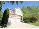 Stunning home with a stone facade, two-car garage, and concrete driveway, set amidst lush greenery at 3219 Ranbir Dr, Durham, NC 27713
