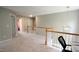 Upstairs loft area featuring neutral carpeting and a view of the staircase at 3219 Ranbir Dr, Durham, NC 27713