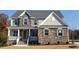 Beautiful two-story home featuring stone accents, shuttered windows, and an inviting front porch at 33 Blackhorn Ct, Pittsboro, NC 27312