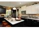 Modern kitchen features an island, stainless steel appliances, and contrasting dark and light cabinets at 33 Blackhorn Ct, Pittsboro, NC 27312