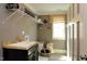 Functional laundry room with sink, shelving, and a patterned window shade at 33 Blackhorn Ct, Pittsboro, NC 27312