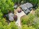 Aerial view of a home, detached structure, and landscaped yard in a wooded setting at 3513 Forest Oaks Dr, Chapel Hill, NC 27514
