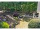 Aerial view of backyard with stone steps leading to a terraced area with a fire pit and lush landscaping at 3513 Forest Oaks Dr, Chapel Hill, NC 27514