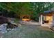 Lush backyard with waterfall, stone steps, cozy terraced area, a covered patio, and landscape lighting at 3513 Forest Oaks Dr, Chapel Hill, NC 27514