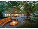 Backyard featuring a fire pit and patio area, surrounded by lush landscaping and the house at 3513 Forest Oaks Dr, Chapel Hill, NC 27514