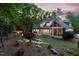 Lush backyard with stone steps, fire pit, patio, screened porch, and landscape lighting at dusk at 3513 Forest Oaks Dr, Chapel Hill, NC 27514