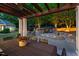 Inviting backyard featuring a patio with pergola, and a stone sitting area with waterfall feature under landscape lighting at 3513 Forest Oaks Dr, Chapel Hill, NC 27514