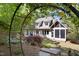 Landscaped backyard featuring a screen porch, stone landscaping, and mature trees at 3513 Forest Oaks Dr, Chapel Hill, NC 27514
