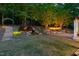 Beautiful backyard with lush greenery, stone steps, a charming waterfall, and outdoor fireplace at 3513 Forest Oaks Dr, Chapel Hill, NC 27514