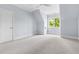 A bedroom with blue walls, neutral carpet, and a bright window at 3513 Forest Oaks Dr, Chapel Hill, NC 27514