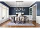 Dining room with a blue accent wall, modern lighting, and hardwood floors at 3513 Forest Oaks Dr, Chapel Hill, NC 27514