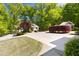 Long concrete driveway leads to a detached building and home, surrounded by mature trees at 3513 Forest Oaks Dr, Chapel Hill, NC 27514