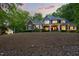 Attractive two-story home with stone accents, well-manicured lawn and trees in the background, seen at dusk at 3513 Forest Oaks Dr, Chapel Hill, NC 27514
