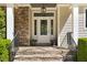 Stone and siding accent the covered front door with a sidelight and stylish light fixture at 3513 Forest Oaks Dr, Chapel Hill, NC 27514