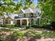Attractive two-story home with stone accents, well-manicured lawn, and inviting front porch framed by lush greenery at 3513 Forest Oaks Dr, Chapel Hill, NC 27514