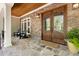 Inviting front porch boasts stone flooring, wood ceiling, and a stylish double-door entrance, creating a warm welcome at 3513 Forest Oaks Dr, Chapel Hill, NC 27514