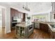 Modern kitchen with a spacious island, granite countertops, dark wood cabinetry, and stainless steel appliances at 3513 Forest Oaks Dr, Chapel Hill, NC 27514