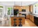 Kitchen features wooden cabinets, a breakfast bar, black appliances, and hardwood floors at 3513 Forest Oaks Dr, Chapel Hill, NC 27514