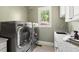 Modern laundry room with granite countertop and front loading washer and dryer at 3513 Forest Oaks Dr, Chapel Hill, NC 27514