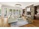 Open living room with stone fireplace, hardwood floors, and large windows at 3513 Forest Oaks Dr, Chapel Hill, NC 27514