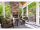 Screened porch with a stone fireplace, tile flooring, and comfortable seating at 3513 Forest Oaks Dr, Chapel Hill, NC 27514