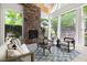Cozy sunroom with a stone fireplace, skylights, and large windows offering scenic views of the surrounding greenery at 3513 Forest Oaks Dr, Chapel Hill, NC 27514