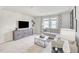 Bright living room with plush carpet, decorative console, and large window offering ample natural light at 3813 Rosebush Dr, Zebulon, NC 27597