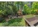 Beautiful backyard with a patio area, lush greenery, and mature trees at 3826 Regent Rd, Durham, NC 27707