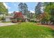 Spacious backyard with mature trees, lush lawn, and outdoor seating area at 3826 Regent Rd, Durham, NC 27707