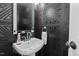 Stylish black powder room featuring a pedestal sink and patterned wall at 3826 Regent Rd, Durham, NC 27707
