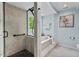 Spa-like bathroom featuring a walk-in shower and soaking tub with natural light at 3826 Regent Rd, Durham, NC 27707