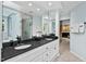 Bright bathroom with dual sinks, dark countertops, and a walk-in shower at 3826 Regent Rd, Durham, NC 27707