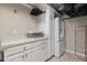 Functional laundry room with storage cabinets, a folding counter, and a refrigerator at 3826 Regent Rd, Durham, NC 27707