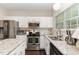 Bright kitchen featuring white cabinets, stainless steel appliances, and granite countertops with hardwood floors at 406 Sapphire Dr, Durham, NC 27703