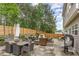 A backyard patio featuring stone pavers, a dark wood fence, and outdoor seating surrounded by lush landscaping at 406 Sapphire Dr, Durham, NC 27703