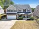 Charming two-story home with a well-manicured lawn and a two-car garage at 421 Gooseberry Dr, Holly Springs, NC 27540