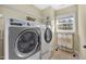 Laundry room with washer, dryer, shelving, and natural light at 421 Gooseberry Dr, Holly Springs, NC 27540