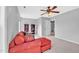 Bright living room with a red sectional couch, neutral walls, and a ceiling fan at 421 Gooseberry Dr, Holly Springs, NC 27540
