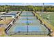 A comprehensive view of multiple fenced tennis courts, lit for evening games, for residents' active lifestyle at 421 Gooseberry Dr, Holly Springs, NC 27540
