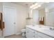 Well-lit bathroom with double sinks, vanity, a mirror, and door for additional storage at 4240 Camden Woods Ct, Raleigh, NC 27612