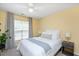 Cozy bedroom showcasing a large window, neutral carpet, ceiling fan, and a comfortable bed at 4240 Camden Woods Ct, Raleigh, NC 27612